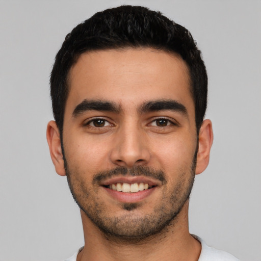 Joyful latino young-adult male with short  black hair and brown eyes