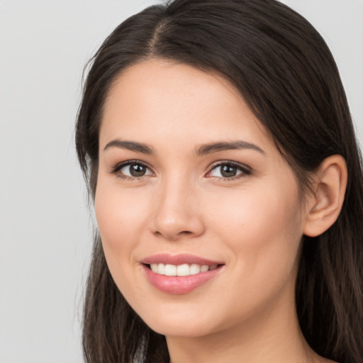 Joyful white young-adult female with long  brown hair and brown eyes