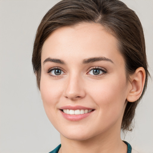 Joyful white young-adult female with medium  brown hair and grey eyes