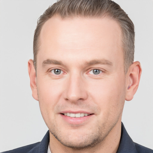 Joyful white adult male with short  brown hair and grey eyes