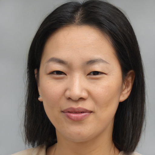 Joyful asian adult female with medium  brown hair and brown eyes