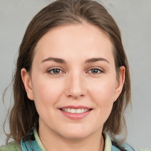 Joyful white young-adult female with medium  brown hair and grey eyes