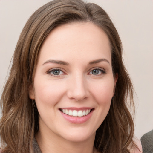 Joyful white young-adult female with long  brown hair and green eyes