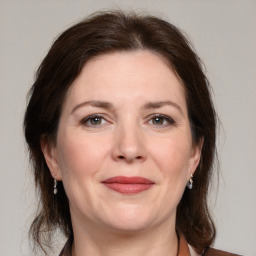 Joyful white adult female with medium  brown hair and grey eyes