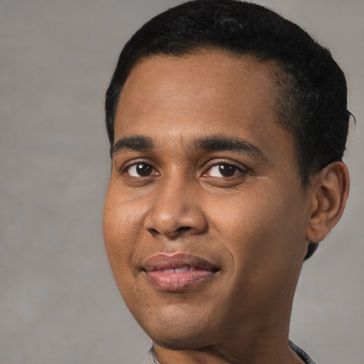 Joyful black young-adult male with short  black hair and brown eyes