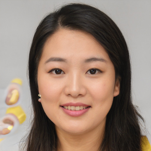 Joyful asian young-adult female with long  brown hair and brown eyes