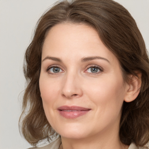 Joyful white young-adult female with medium  brown hair and green eyes