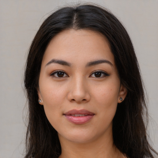 Joyful latino young-adult female with long  brown hair and brown eyes