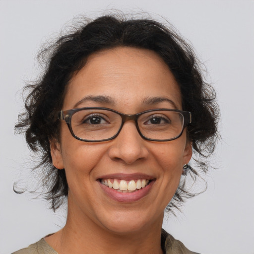 Joyful latino adult female with medium  brown hair and brown eyes