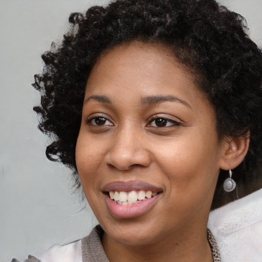 Joyful black young-adult female with medium  brown hair and brown eyes