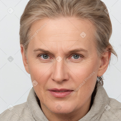 Joyful white adult female with medium  brown hair and blue eyes