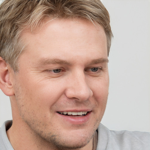 Joyful white adult male with short  brown hair and grey eyes