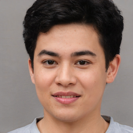 Joyful asian young-adult male with short  brown hair and brown eyes