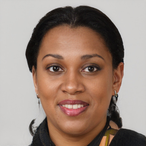 Joyful black adult female with medium  brown hair and brown eyes