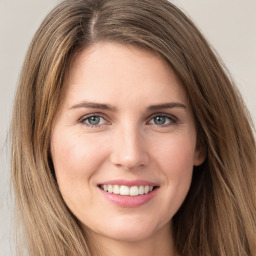 Joyful white young-adult female with long  brown hair and green eyes