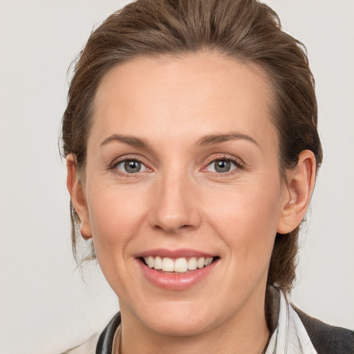 Joyful white young-adult female with medium  brown hair and grey eyes