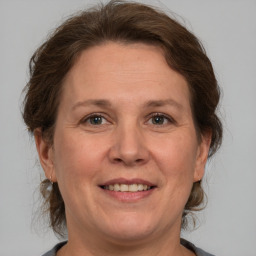 Joyful white adult female with medium  brown hair and grey eyes