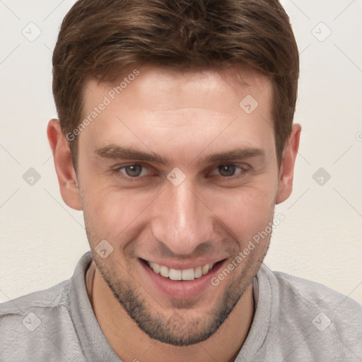 Joyful white young-adult male with short  brown hair and grey eyes