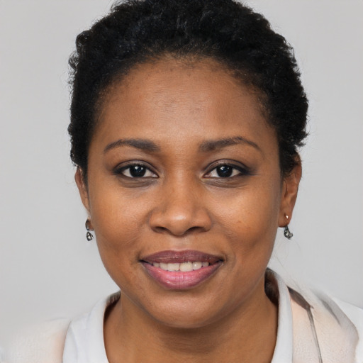 Joyful black young-adult female with short  black hair and brown eyes