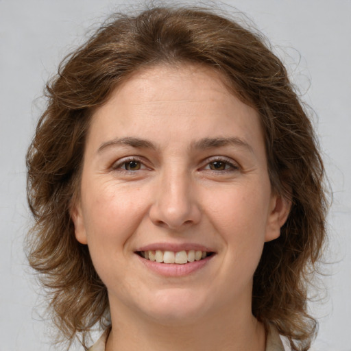 Joyful white adult female with medium  brown hair and green eyes