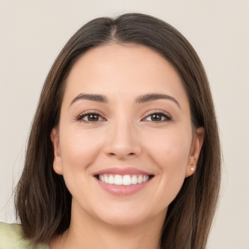 Joyful white young-adult female with long  brown hair and brown eyes