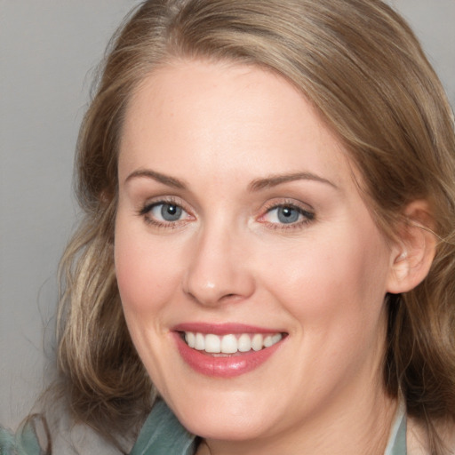 Joyful white young-adult female with medium  brown hair and blue eyes