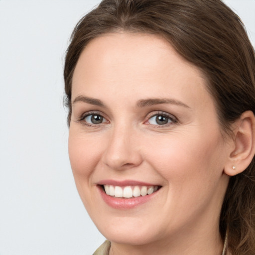 Joyful white young-adult female with long  brown hair and grey eyes