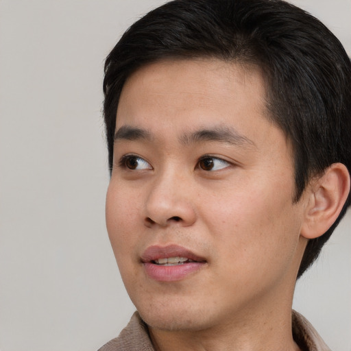Joyful asian young-adult male with short  brown hair and brown eyes