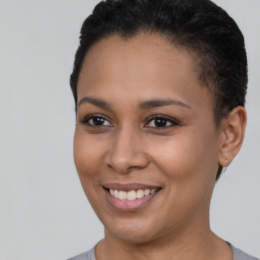 Joyful black young-adult female with short  brown hair and brown eyes