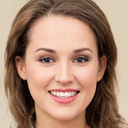 Joyful white young-adult female with long  brown hair and green eyes