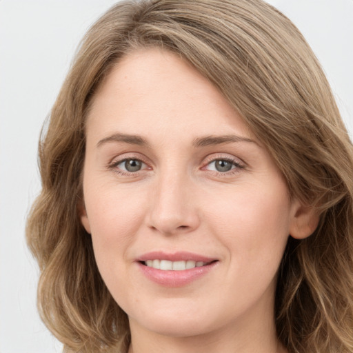 Joyful white young-adult female with long  brown hair and blue eyes