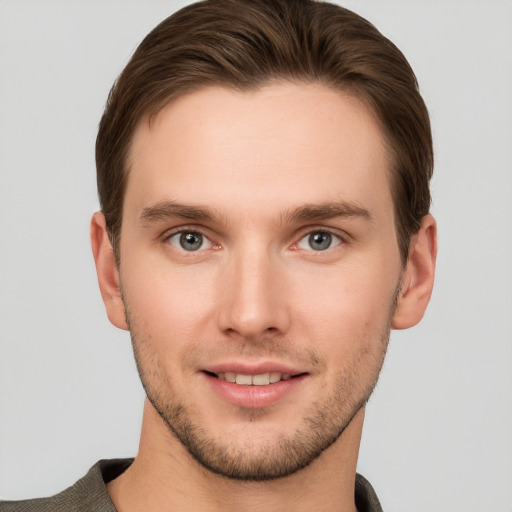 Joyful white young-adult male with short  brown hair and grey eyes