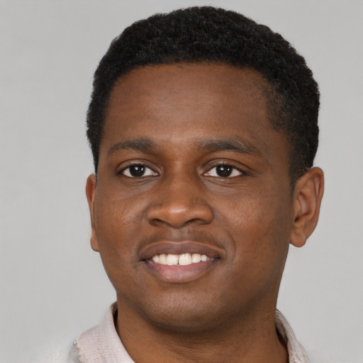 Joyful black young-adult male with short  brown hair and brown eyes