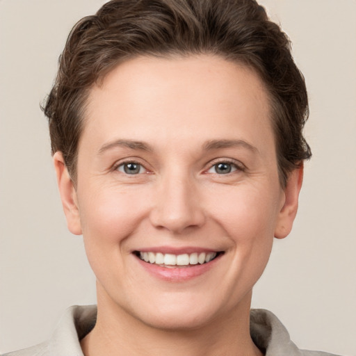 Joyful white young-adult female with short  brown hair and grey eyes