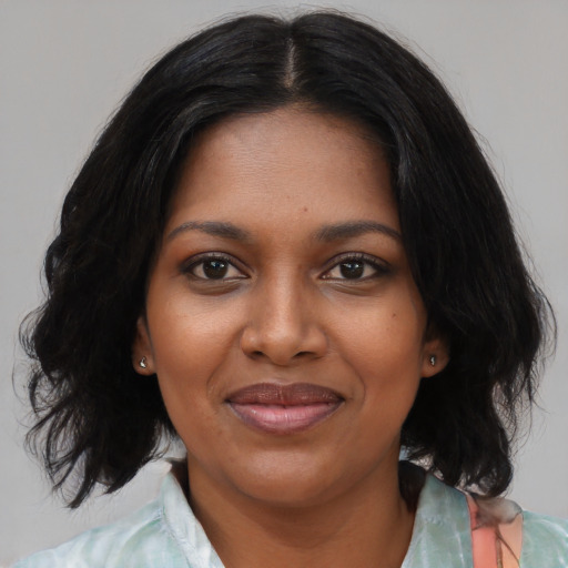 Joyful black young-adult female with medium  black hair and brown eyes