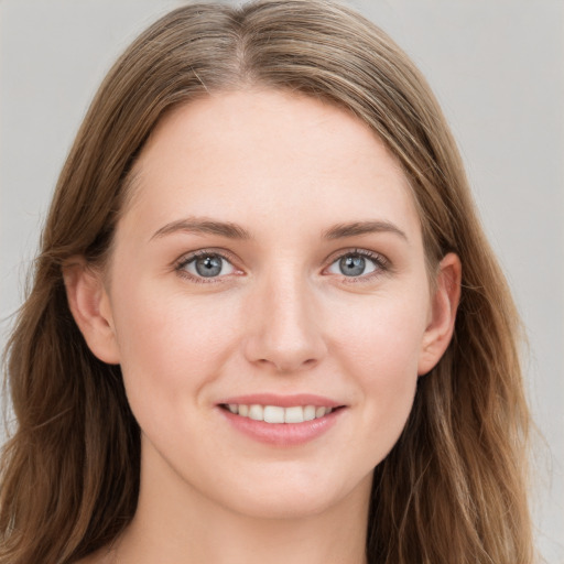 Joyful white young-adult female with long  brown hair and blue eyes