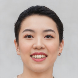 Joyful asian young-adult female with short  black hair and brown eyes