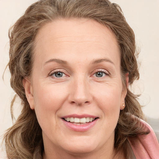 Joyful white adult female with long  brown hair and grey eyes