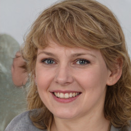 Joyful white adult female with medium  brown hair and blue eyes