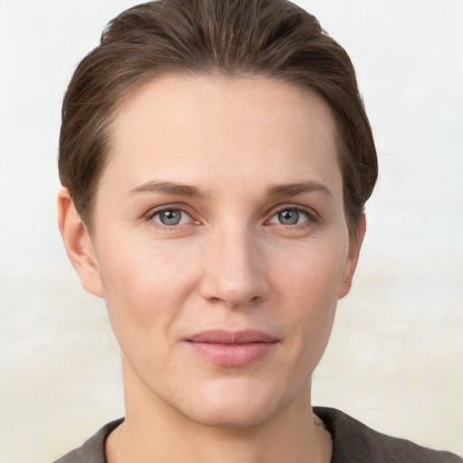 Joyful white young-adult female with short  brown hair and grey eyes