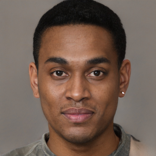 Joyful black young-adult male with short  brown hair and brown eyes