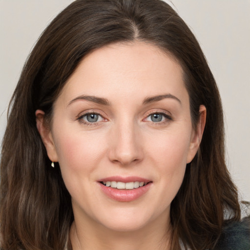 Joyful white young-adult female with long  brown hair and grey eyes