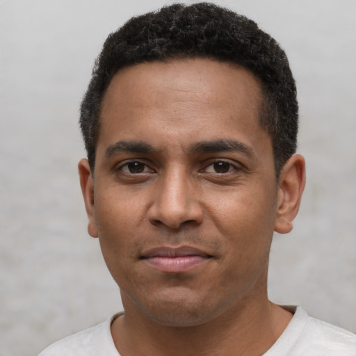 Joyful black young-adult male with short  black hair and brown eyes
