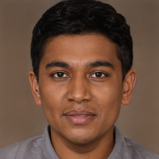 Joyful black young-adult male with short  black hair and brown eyes
