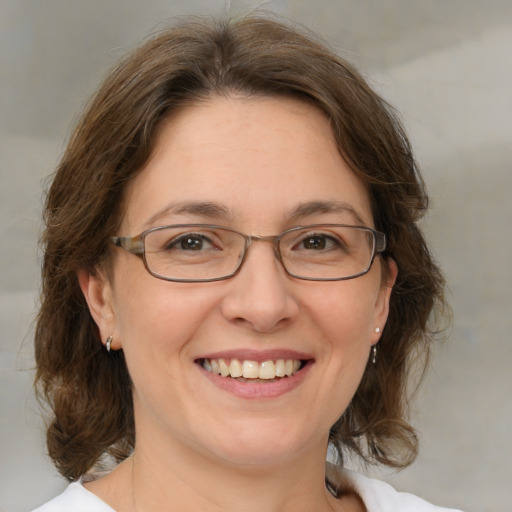 Joyful white adult female with medium  brown hair and blue eyes