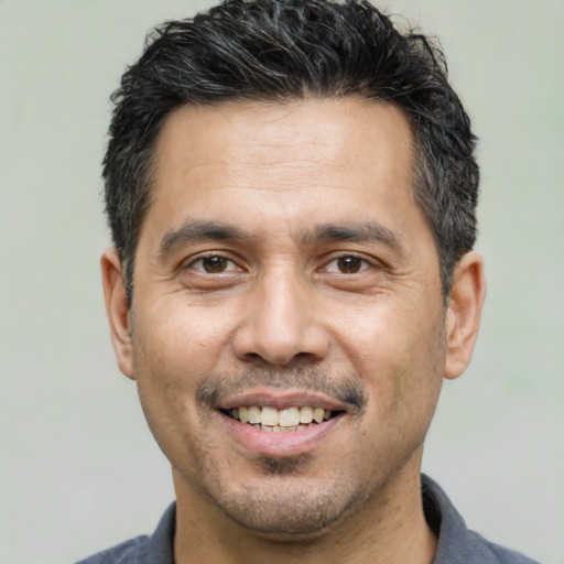 Joyful white adult male with short  black hair and brown eyes