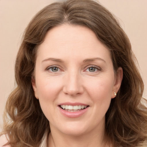 Joyful white adult female with long  brown hair and grey eyes