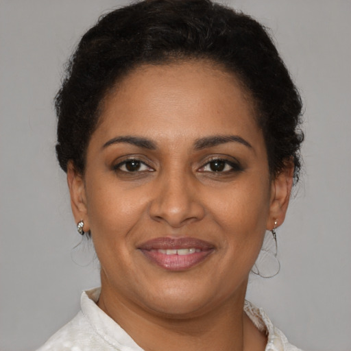 Joyful latino adult female with short  brown hair and brown eyes