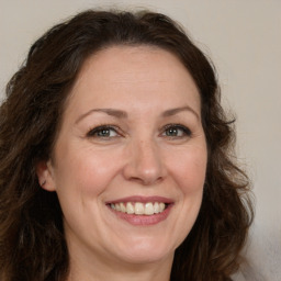 Joyful white adult female with long  brown hair and brown eyes