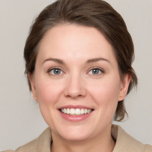 Joyful white young-adult female with medium  brown hair and grey eyes